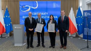 4 osoby pozujące do zdjęcia z dyplomami